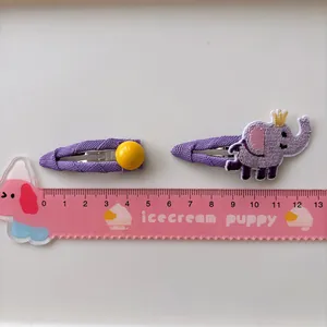 Two-piece set of purple fabric children's hair clips with embroidered baby elephant and yellow ball