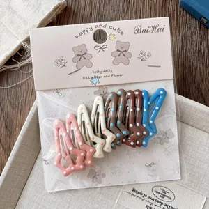 Détail du lot de 10 barrettes en forme d'étoile avec pois colorés en tons chauds