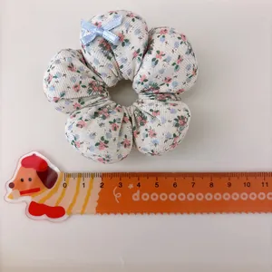 Floral print fabric scrunchie for girls with light blue bow and measuring ruler