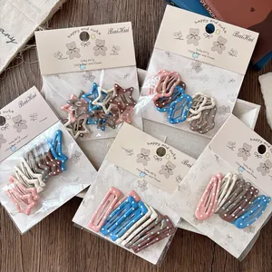 Détail de diverses barrettes à cheveux en métal à pois colorés pour filles sous emballage