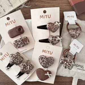 Leopard print star and heart hair clips and scrunchies set on elegant wooden background