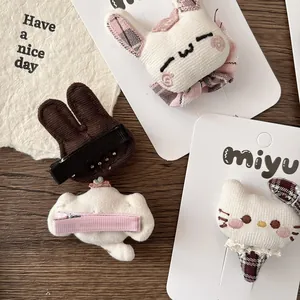 Barrettes peluche animaux 3D avec motifs lapin et chat sur fond en bois sombre