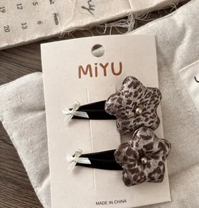 Detail of leopard print star hair clips with mini bows and rivets on card packaging
