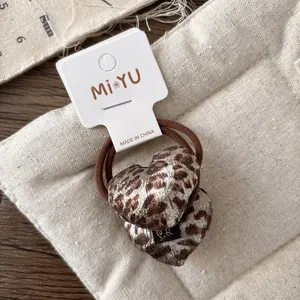 Close-up of leopard print heart elastic hair ties on a display card for girls