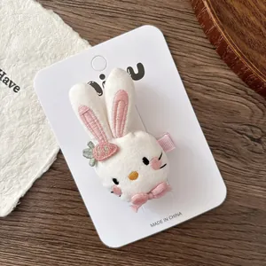 Détail de la pince à cheveux lapin en peluche avec broderie rose et petit nœud