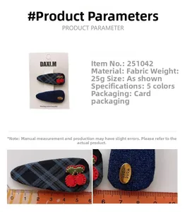 Detailed macro view of navy plaid hair clips with cherry embroidery and handmade metal label