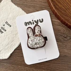 Détail de la barrette lapin fleurie avec rembourrage en coton et perles sur carton