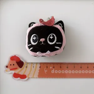 Pince à cheveux chat en peluche noire avec capuche rose et nœud, 4cm sur fond blanc