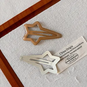 Star-shaped cutout snap hair clips in brown and cream colors for girls and women