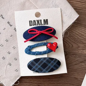 Three-piece hair clip set with denim patterns, plaid fabric, and cute red bow details
