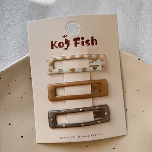 Three-piece set of brown bear plaid and solid hair clips on a display card
