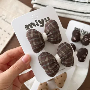 Paire de barrettes à nœud papillon à carreaux marron pour enfants sur carte