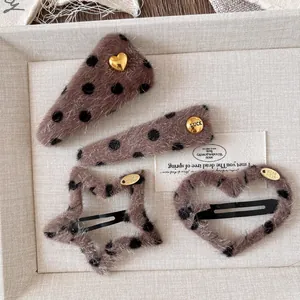 Detail of four leopard print plush hair clips in star, heart, and geometric shapes