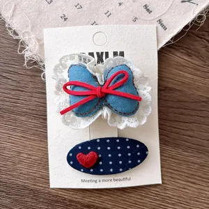 Detail of navy blue plaid bow and polka dot heart hair clips set on display card