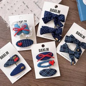 Detail view of navy blue plaid and polka dot bow hair clips on display card