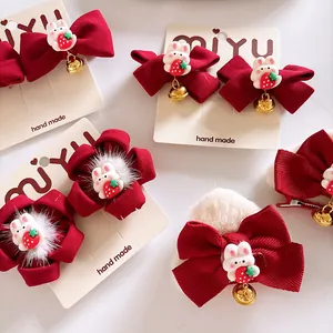 Détail de pince à cheveux rouge avec oreilles de chat, lapin et clochette dorée