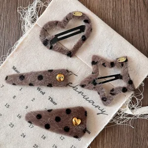 Set of four leopard print plush hair clips with heart and star shapes and gold details