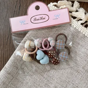 Detalle de gomas para el pelo con diseño de cuadros y corazones en su empaque