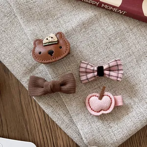 Set of four handmade fabric and leather hair clips with cute bear and bow designs