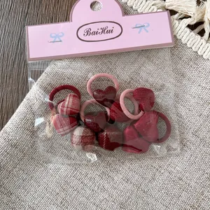 Detalle del juego de 10 gomas de pelo para niñas con corazones de cuadros y bandas