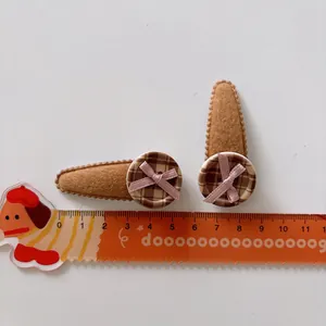 Close-up of brown teardrop felt hair clips with check buttons and pink bows