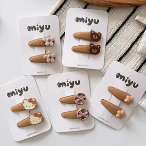 Close-up of brown felt hair clips for kids featuring bear, flower, and star motifs