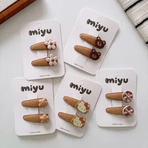 Close-up of brown plush hair clips set featuring cute bears, flowers and stars on card