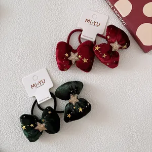 Dettaglio di fermagli natalizi in velluto con fiocchi a paillettes e stelle nella confezione