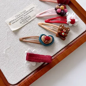 Detail of cute cartoon hair clips showing the rabbit design and red fabric wrap backing