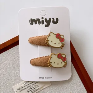 Close-up of Hello Kitty hair clips for girls on display card with soft wooden background