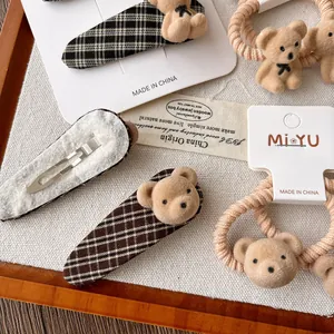 Detail of cute flocked bear hair clips and checkered scrunchies on a display card
