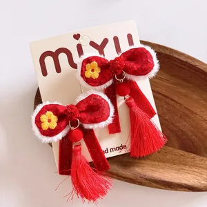 Detalle de horquillas de lazo rojo con ribete de piel y borlas para el Año Nuevo Chino