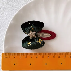Fermaglio di Natale con fiocco in velluto verde, stelle dorate e base in maglia rossa