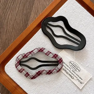 Lot de deux pinces à cheveux ondulées en noir brillant et tissu à carreaux rouge et blanc
