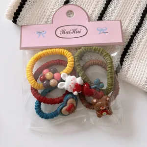 Detail of cute rabbit and bear cartoon hair ties in colorful ribbed elastic sets