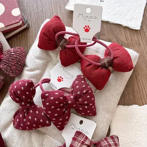 Red plaid and solid sweet bow hair ties set for girls on a cream fabric background