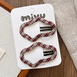 Détail de pinces à cheveux BB en forme de nuage à carreaux rouges et blancs sur carte