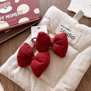 Detail of two red polka dot bow hair ties on a card head with elastic rope bands