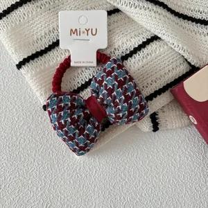 Detalle de coletero con lazo de pata de gallo azul y rojo con banda elástica roja
