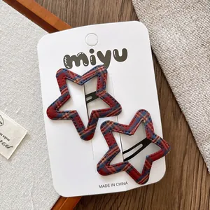 Gros plan de barrettes à cheveux en forme d'étoile avec motif à carreaux rouge et bleu