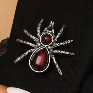 Macro view of vintage spider brooch with red stones pinned to a black suit lapel