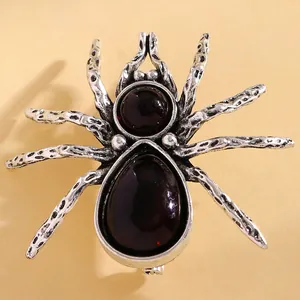 Macro detail of gothic spider brooch with vintage silver metal and deep red gemstones