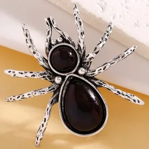 Macro view of a retro silver spider brooch featuring vintage textures and inlaid gemstones