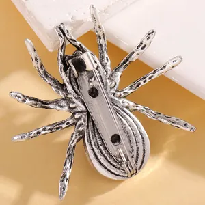 Macro detail of gothic spider brooch back featuring vintage silver finish and safety pin clasp