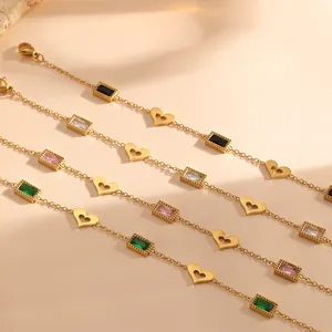 Detailweergave van stalen armbanden met holle harten en kleurrijke rechthoekige stenen.