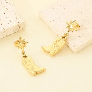 Detailed view of gold stainless steel cowboy boot earrings with star studs on stone.