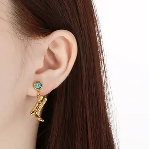 Detailed view of gold stainless steel earring with turquoise and cowboy boot pendant