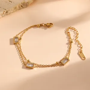 Gedetailleerd beeld van goudkleurige roestvrijstalen dubbellaagse armband met rechthoekige stenen