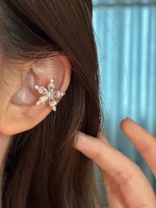 Close-up detail of a sparkling zirconia star ear cuff for non-pierced ears on model ear