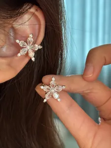 Close-up detail of a sparkling star-shaped ear cuff with cubic zirconia on an ear